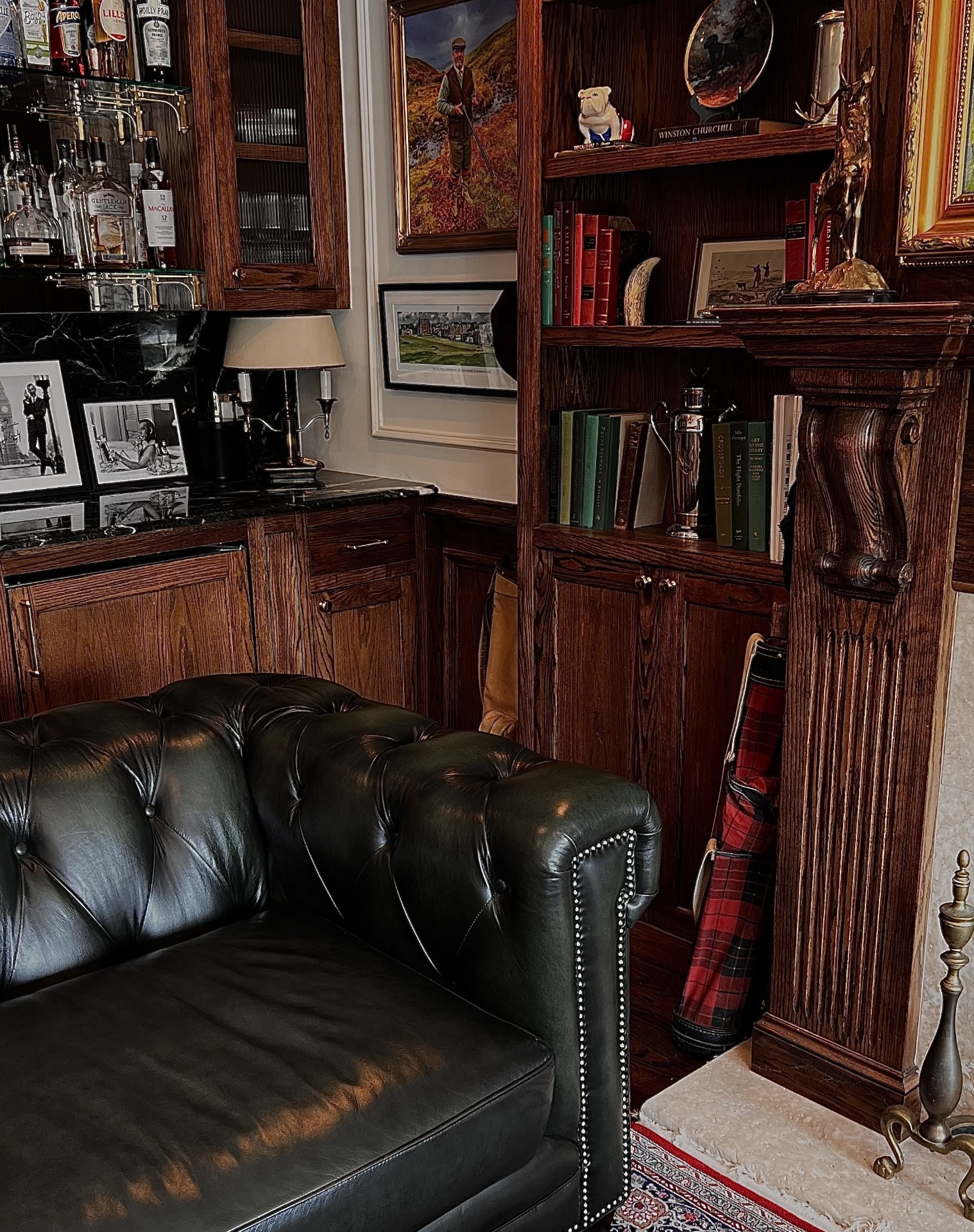 Dark panelled fitting room with leather seating and shelves of books